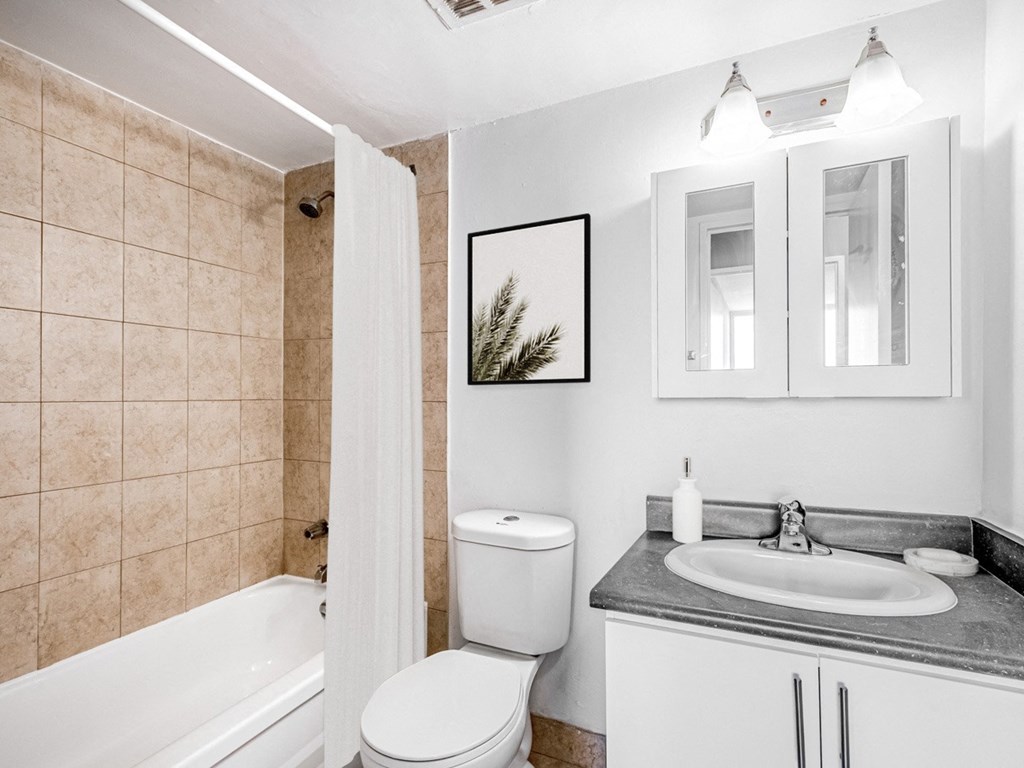 A bathroom with a toilet, sink, and bathtub.