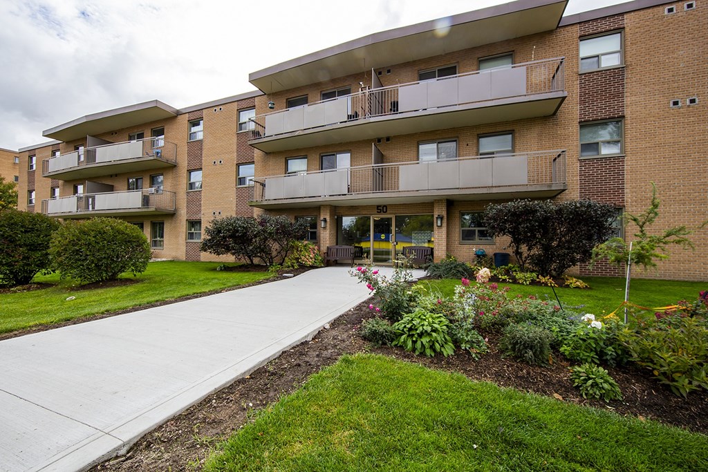 Apartment building with a walkway in front of it.