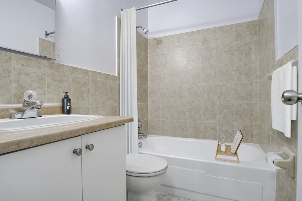 A white bathroom with a toilet, sink, and bathtub.