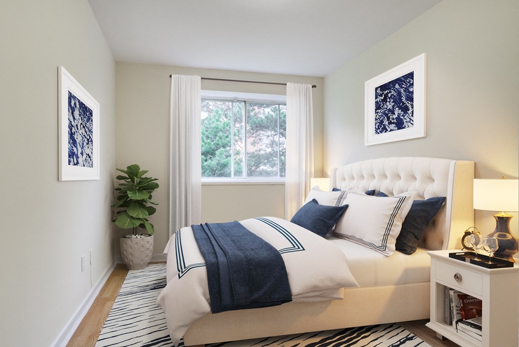 A bedroom with a large bed and a plant.