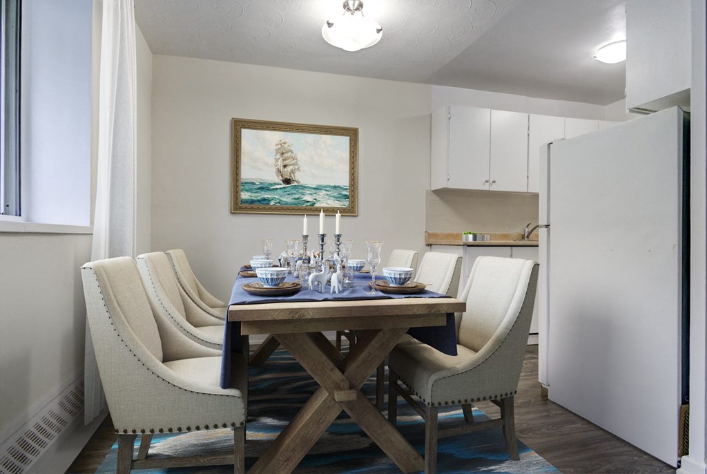 A dining room with a wooden table and chairs.