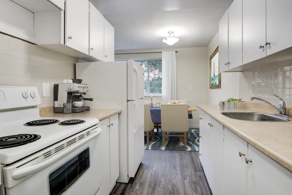 A kitchen with white appliances and cabinets.