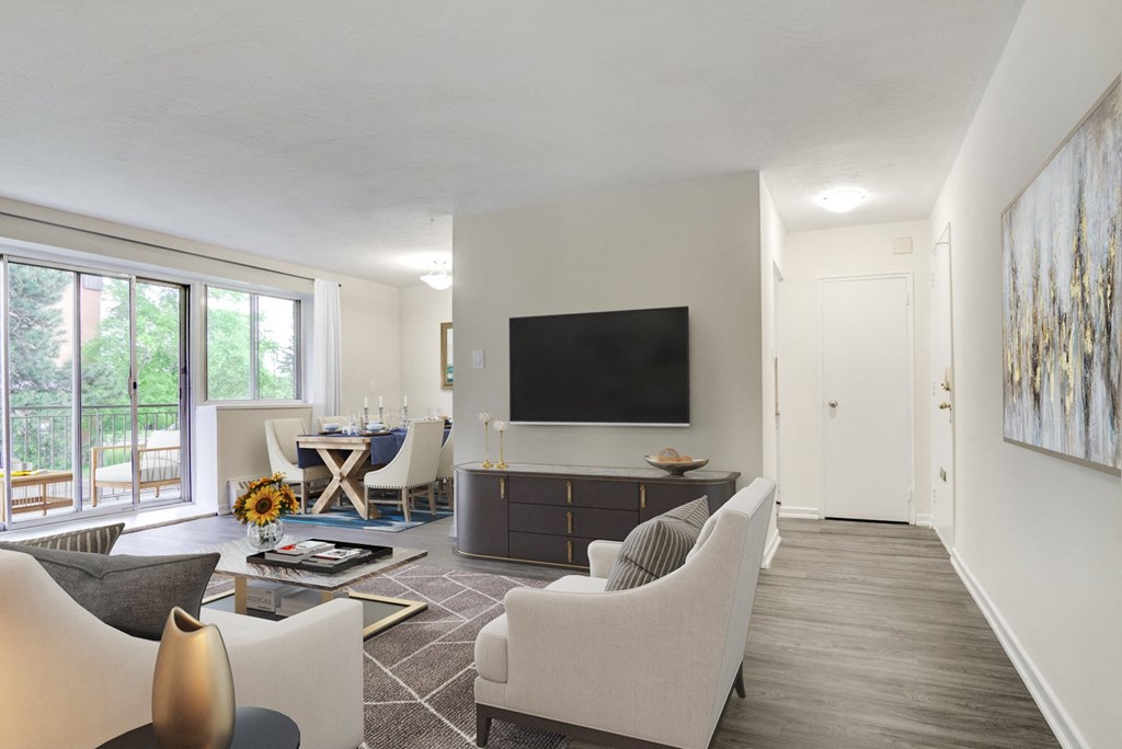 A living room with a white couch and a television on the wall.