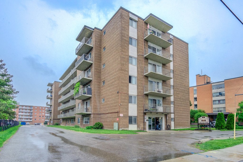 A tall apartment building with a flag on the top floor.