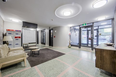 A waiting room with a couch, chairs, and a table.