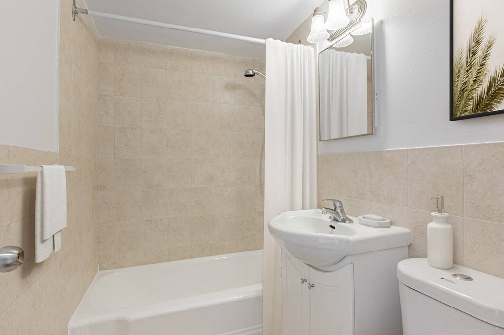 A white bathroom with a sink, toilet, and bathtub.