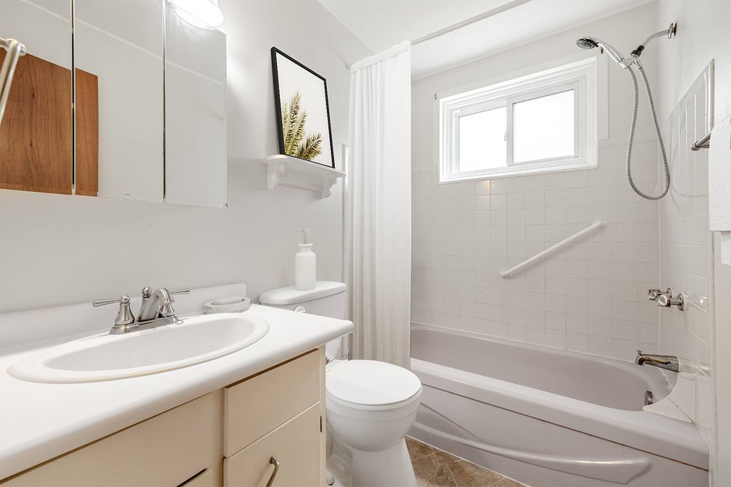 A white bathroom with a toilet, sink, and bathtub.