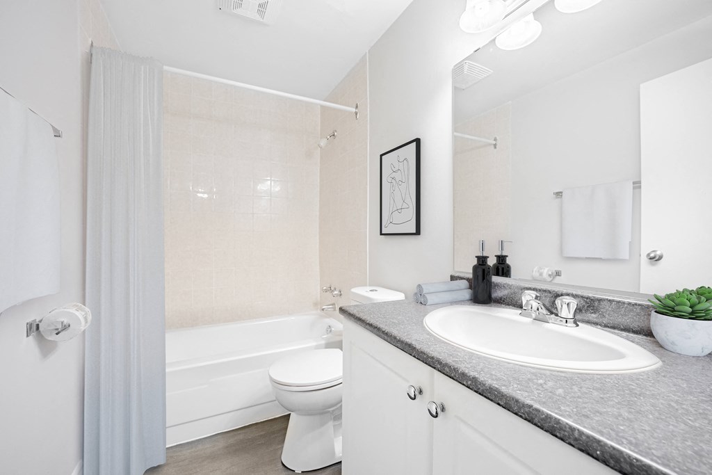 A white bathroom with a toilet, sink, and bathtub.