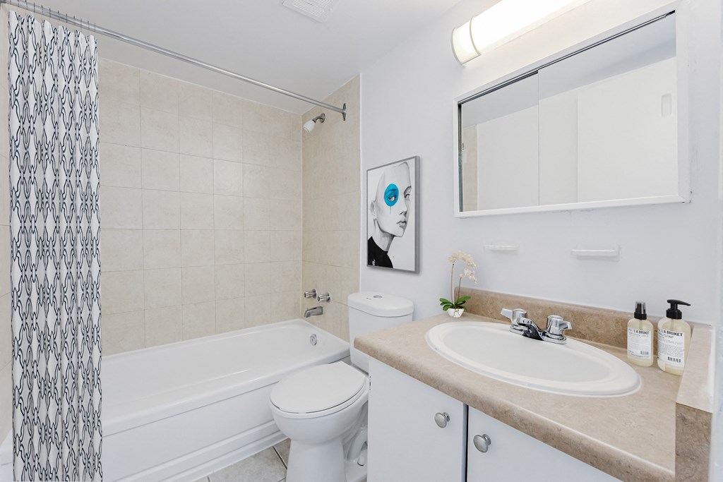 A white toilet sits next to a bathtub in a bathroom.