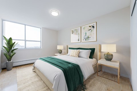 A bedroom with a large bed and a green blanket.