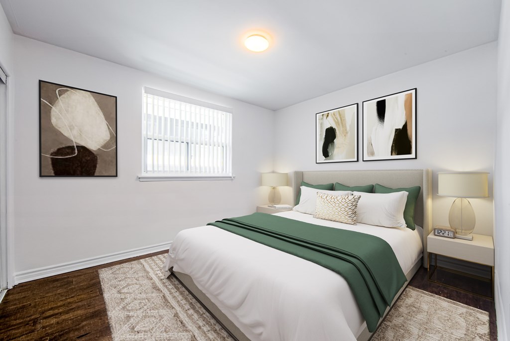 A bedroom with a bed, two lamps, and two pictures on the wall.
