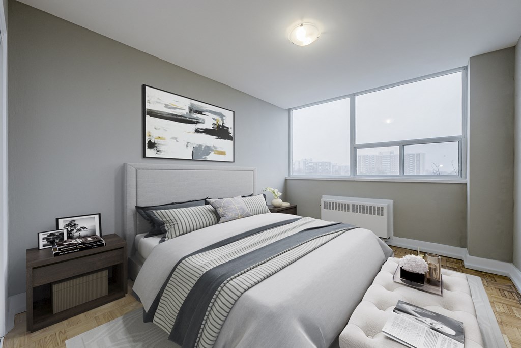 A bedroom with a large bed and a picture on the wall.