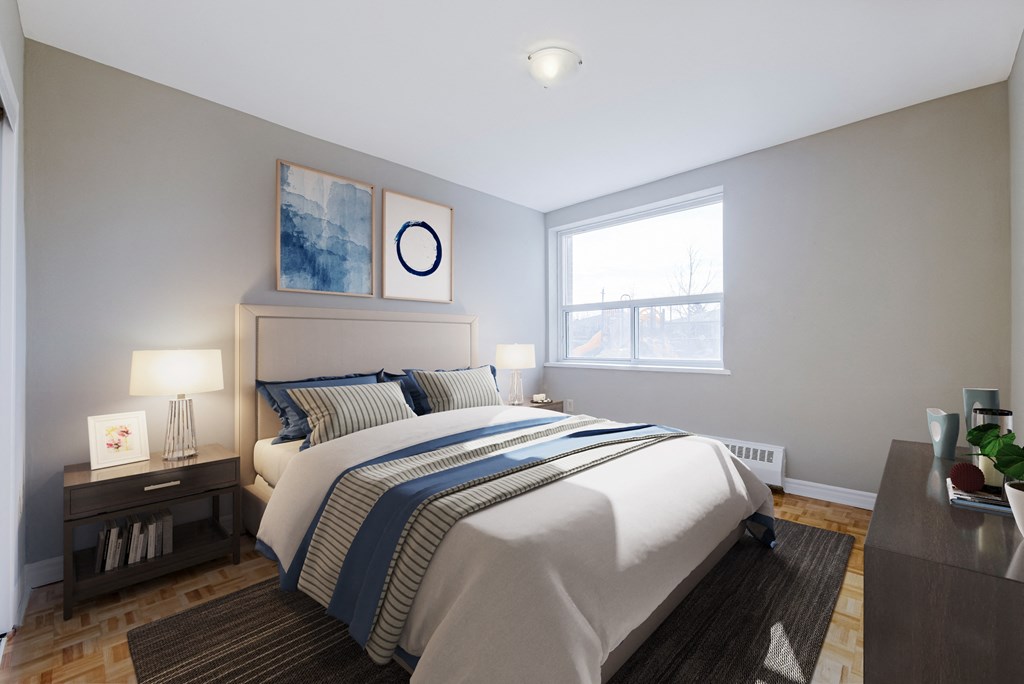 A bedroom with a large bed and a nightstand with a lamp.