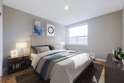 A bedroom with a large bed and a nightstand with a lamp.