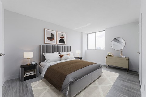 A bedroom with a large bed and a nightstand with a lamp.