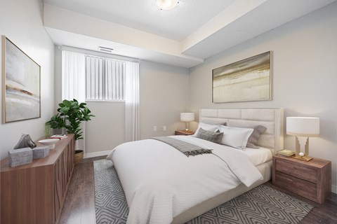 A well-lit bedroom with a large bed and a wooden nightstand.