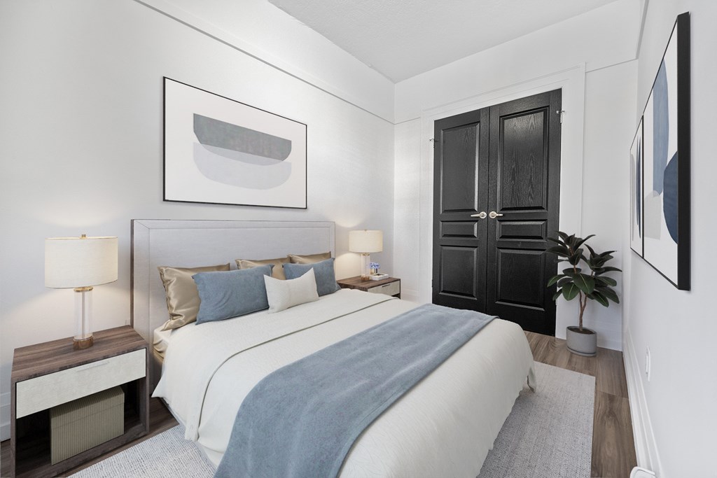 A bedroom with a large bed and a painting on the wall.