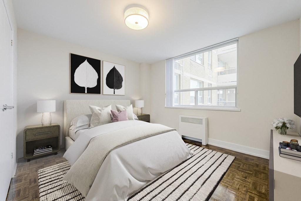 A bedroom with a large bed and a window.