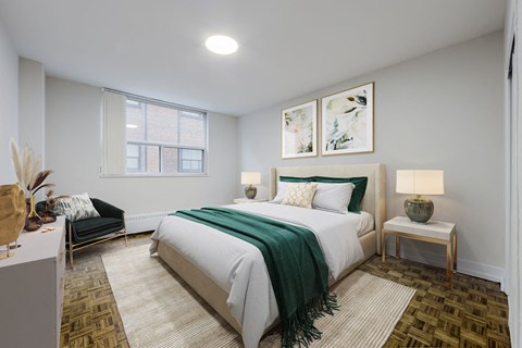 A bedroom with a large bed and a green blanket.