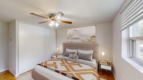 A bedroom with a large bed and a ceiling fan.