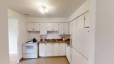 A kitchen with white appliances and cabinets.