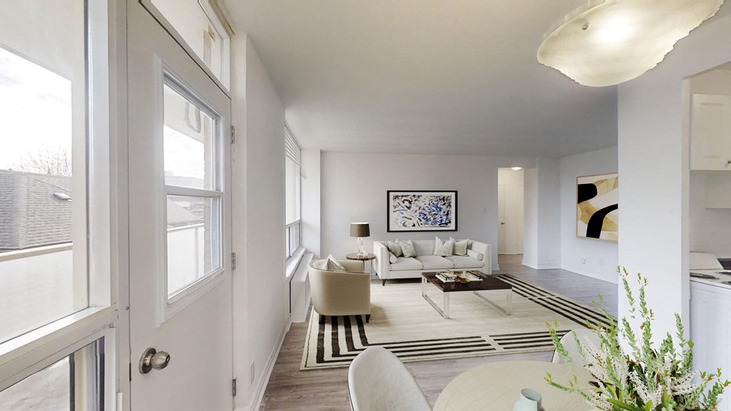 A white living room with a couch, chairs, and a coffee table.