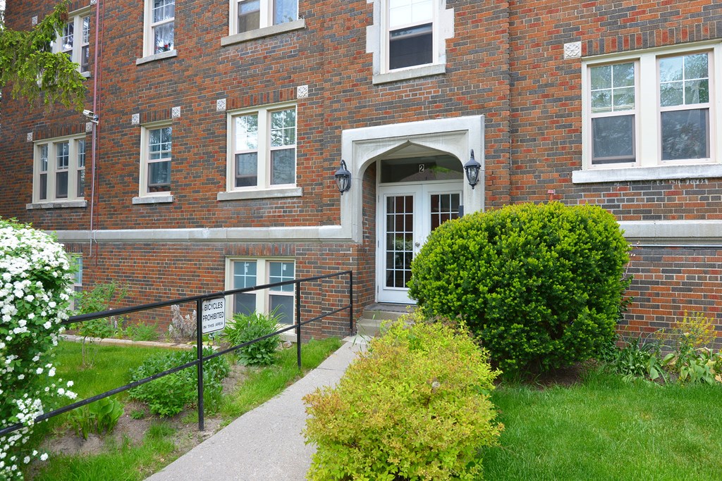 A red brick building with a white door and windows.