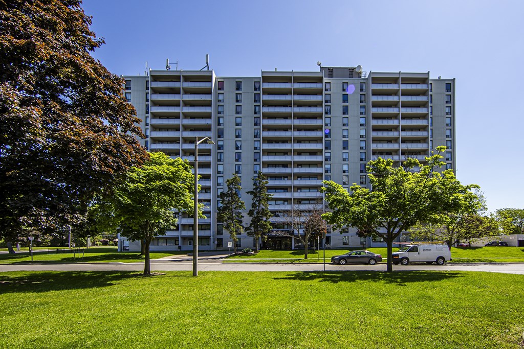 A tall building with a green lawn in front of it.
