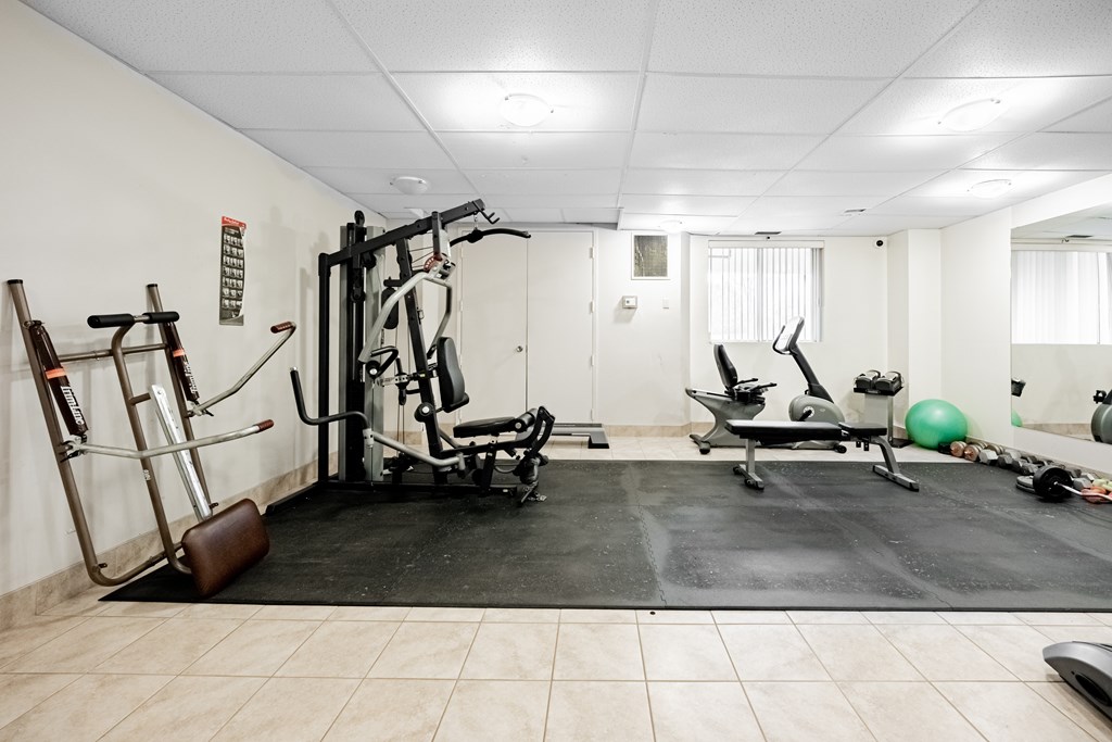 A gym room with a variety of exercise equipment.