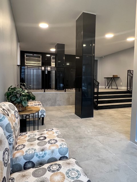 A living room with a couch, a table, and a plant.