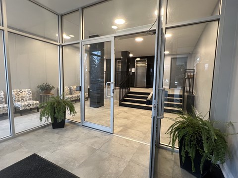 A glass door with a black mat in front of it.