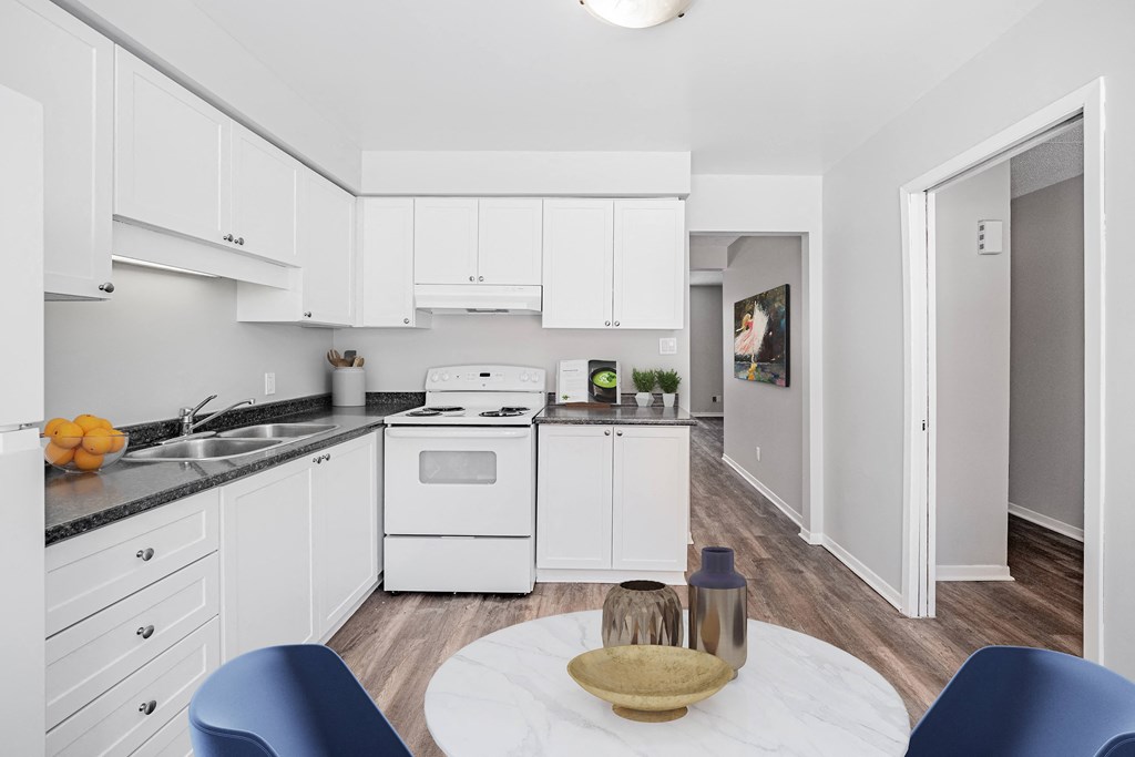 A modern kitchen with white cabinets and a wooden table.