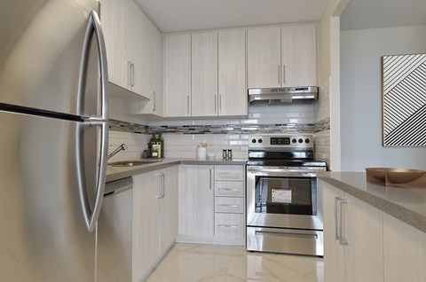 A modern kitchen with a stainless steel refrigerator and oven.