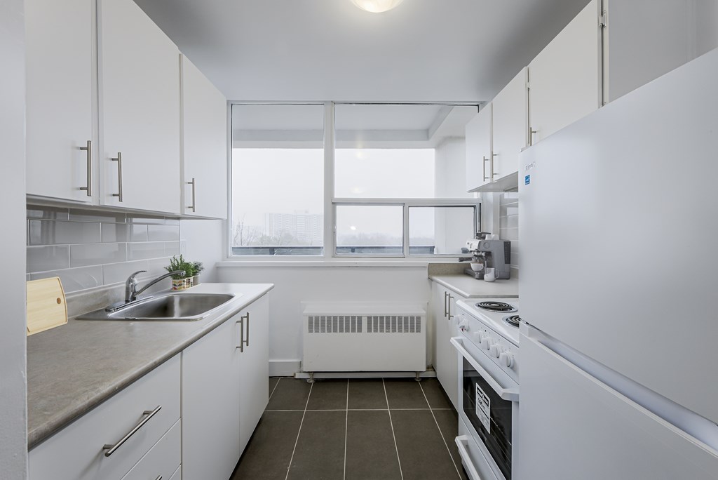 A modern kitchen with white appliances and cabinets.