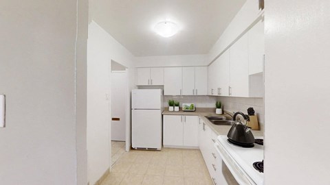A kitchen with white appliances and cabinets.