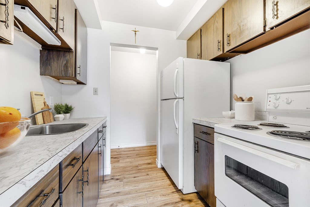 A kitchen with a white fridge, stove, and oven.