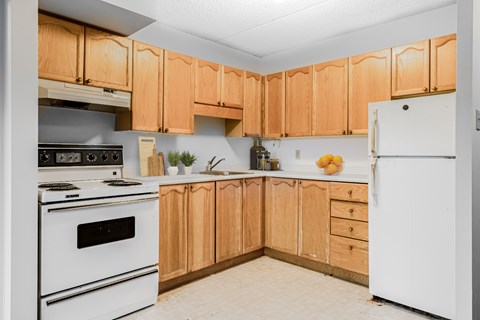 A kitchen with wooden cabinets and white appliances.