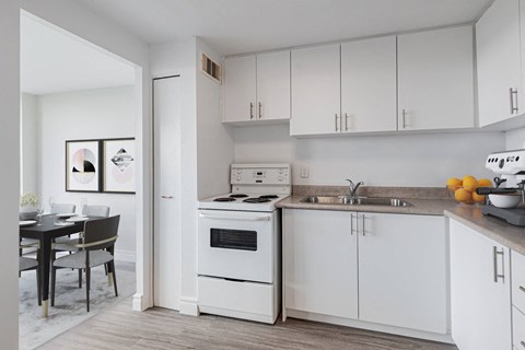 A kitchen with white appliances and cabinets.