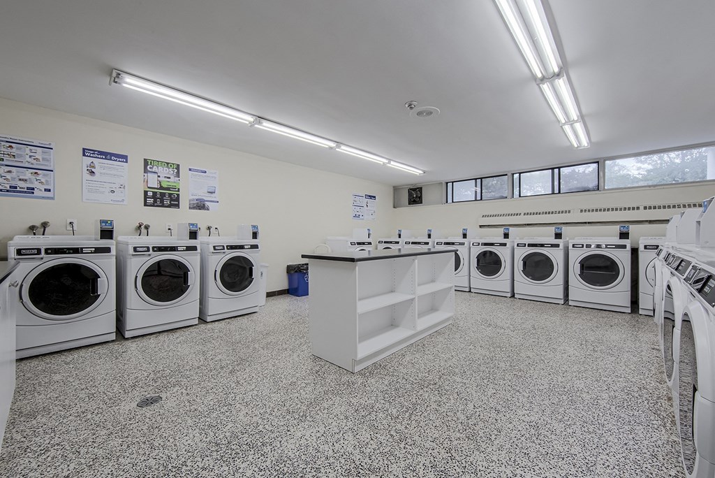 A laundromat with several washing machines and a counter.
