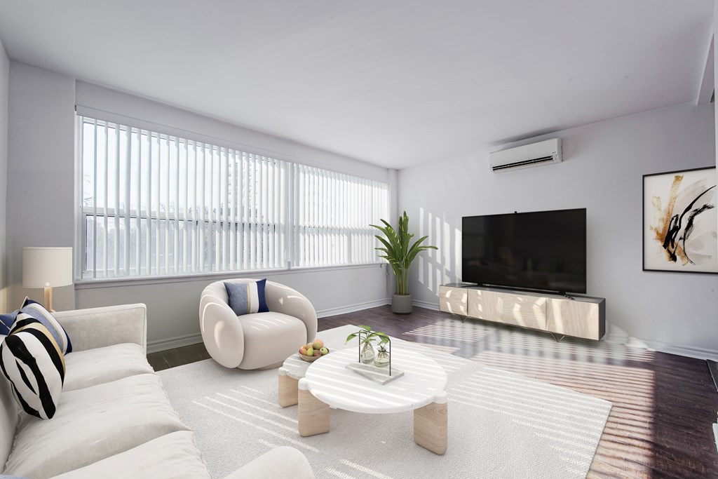 A modern living room with a white sofa, a white armchair, a white coffee table, and a flat screen TV.