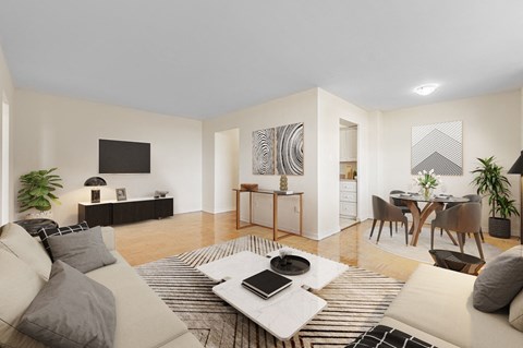 A modern living room with a white couch, a coffee table, and a television.