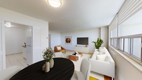 A dining table with a vase on it and a couch in the background.