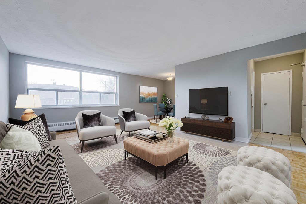 A living room with a grey sofa, a brown coffee table, and a television.