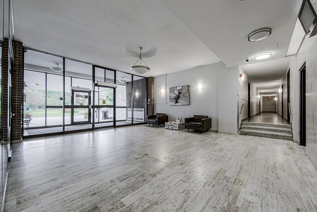 A spacious room with wooden flooring and a staircase leading to another room.