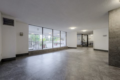 A spacious office room with a view of the outdoors through large windows.