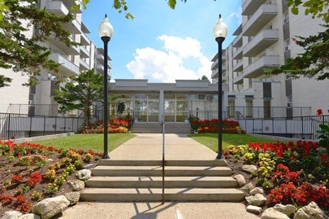 A building entrance with a black fence and red flowers.