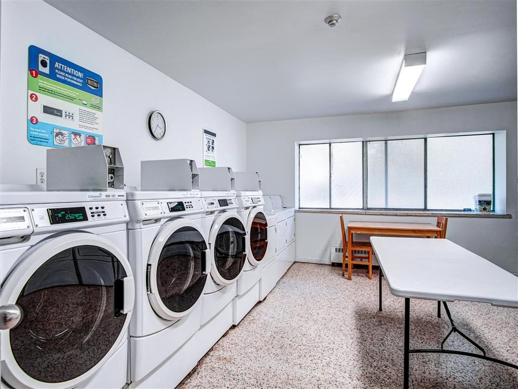 A laundromat with a row of washers and dryers.