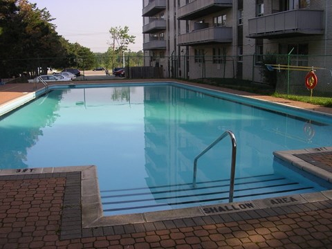 A swimming pool with a warning sign that says shallow area.