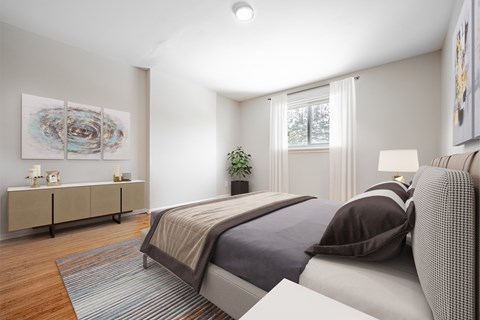 A bedroom with a large bed and a painting on the wall.