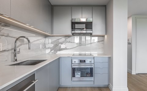A modern kitchen with a stainless steel oven and sink.